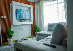 a living room with a couch and a tv at Urban Elegance in Nairobi