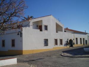 a large white building with windows on a street at Betica Hotel Rural in Pias