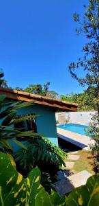 a house with a swimming pool in the middle of a yard at Casa Cica in Ubatuba
