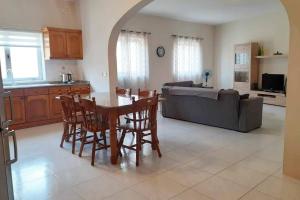 cocina y sala de estar con mesa y sillas en Nr41 Holiday Apartment - Spacious & Bright 3 Bedroom, 2 Bathroom Apartment - Marsaxlokk Malta, en Marsaxlokk