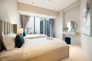 1 Schlafzimmer mit 2 Betten und einem großen Fenster in der Unterkunft Magnificent 3BR Spectacular Canal & Burj View in Dubai