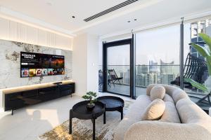 ein Wohnzimmer mit einem Sofa und einem großen Fenster in der Unterkunft Magnificent 3BR Spectacular Canal & Burj View in Dubai