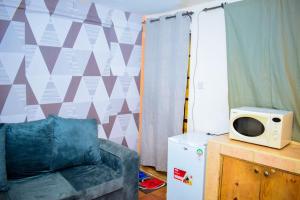 ein Wohnzimmer mit einem Sofa und einer Mikrowelle in der Unterkunft Bosslady staycation A4 in Muchatha