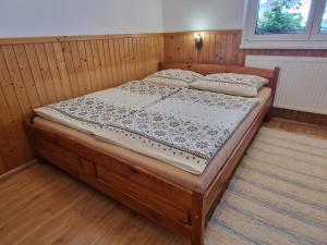 a bedroom with a wooden bed in a room at Apartmány Lýdia in Zuberec