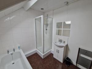 a white bathroom with a shower and a sink at Fantastic 4 Bed for Contractors and Families in Old Walker