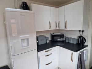 a kitchen with a white refrigerator and a microwave at Fantastic 4 Bed for Contractors and Families in Old Walker