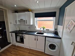 a kitchen with a sink and a washing machine at Fantastic 4 Bed for Contractors and Families in Old Walker