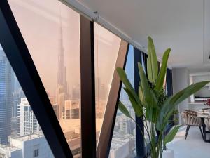 a room with a large window with a plant at Magnificent 3BR Spectacular Canal & Burj View in Dubai