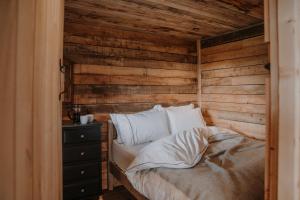 a bed in a room with a wooden wall at Woolly Wood Cabins - Bryn in Llandrindod Wells