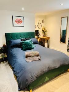 a bedroom with a large bed with a green headboard at Grade II boho home in the heart of Oxford St. in Southampton