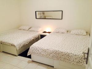 1 dormitorio con 2 camas y espejo en la pared en Villa paisible et agréable, en Morières-lès-Avignon