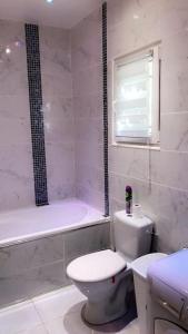 y baño blanco con aseo y bañera. en Villa paisible et agréable, en Morières-lès-Avignon