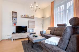een woonkamer met een bank en een tv bij Villa Sabinium in Heringsdorf