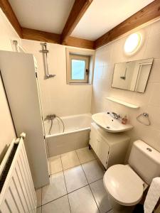 a bathroom with a sink and a toilet and a tub at Zeepark Haerendycke in Wenduine