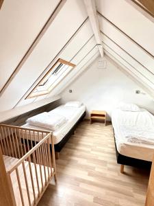 a attic bedroom with two beds and a staircase at Zeepark Haerendycke in Wenduine
