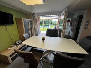 a table and chairs in a room with a table at Ferienhaus Zeulenrodaer Meer in Stelzendorf