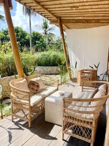 een patio met 2 rieten stoelen en een tafel bij Nusava Boutique Hotel in Nusa Penida
