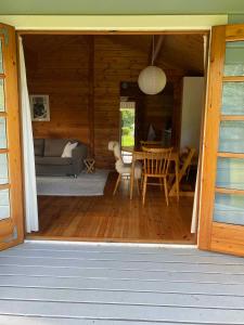 een veranda van een houten hut met een tafel en een bank bij Family-friendly Cottage By Stoense Beach in Tranekær