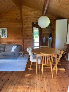 een woonkamer met een tafel en een bank bij Family-friendly Cottage By Stoense Beach in Tranekær