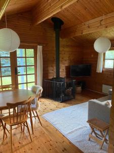 - un salon avec une table et une cheminée dans l'établissement Family-friendly Cottage By Stoense Beach, à Tranekær