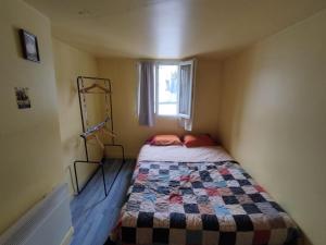 - une petite chambre avec un lit et une fenêtre dans l'établissement Giallo, à Paris