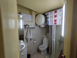 La petite salle de bains est pourvue de toilettes et d'un lavabo. dans l'établissement Giallo, à Paris