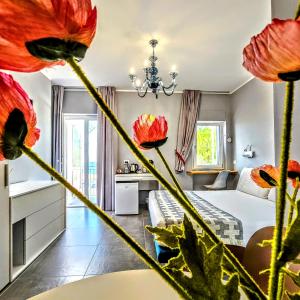 a bedroom with a bed with red flowers in the foreground at A Casa di Alessandra - Rooms in Castellabate
