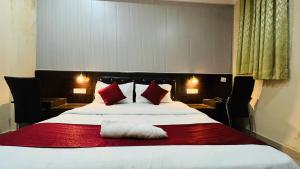 a bedroom with a large bed with red and white pillows at CORAL TREE INN in Lucknow