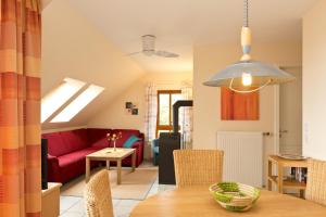 a living room with a red couch and a table at Haus Sarah 4 Am Lorenweg 10 in Göhren-Lebbin