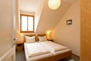 a bedroom with a bed with white sheets and a window at Haus Sarah 4 Am Lorenweg 10 in Göhren-Lebbin