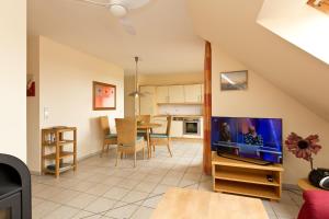a living room with a tv and a kitchen at Haus Sarah 4 Am Lorenweg 10 in Göhren-Lebbin