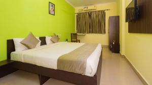 波尔沃林Hotel Spring Height Hotels Near Mall De Goa的一间卧室设有一张带绿色墙壁的大床