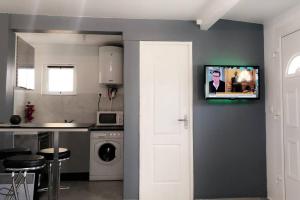 a kitchen with a tv hanging on a wall at studio Pondichéry moderne in Morières-lès-Avignon