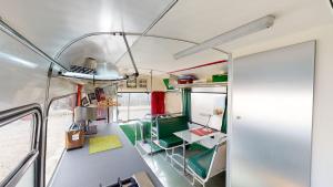 an interior of an rv with a table and a desk at The Gozo Bus in Taʼ Ħamet