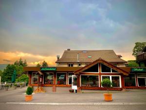 a restaurant with a building with a roof at Hôtel - Restaurant Le Couchetat in La Bresse