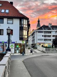 a street in a city with buildings and a sunset at Zalár Apartman in Eger