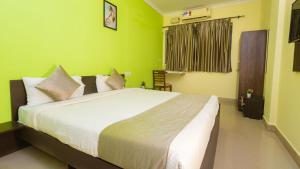 波尔沃林Hotel Spring Height Hotels Near Mall De Goa的一间卧室设有一张带绿色墙壁的大床 更多37张照片