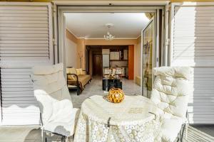 a porch with a table and two white chairs at Ki &Ki apartments New Michaniona in Néa Michanióna