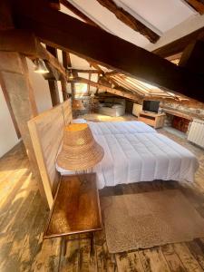 Casa Rural Basiver - Suite Basiver في Armaño: غرفة نوم مع سرير مع قبعة من القش عليه