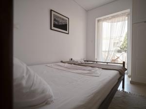 łóżko w białym pokoju z oknem w obiekcie tripoli center apartment w mieście Tripolis