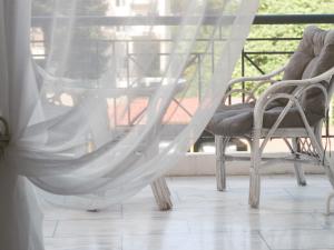 a hammock on a porch with chairs and a table at tripoli center apartment in Tripolis