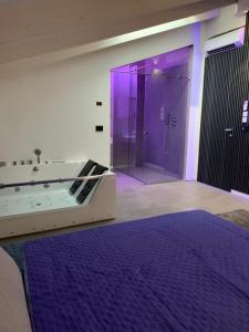 a bathroom with a purple shower and a tub at Villa Primodì in Bologna