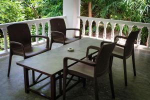 a table and four chairs on a porch at Panna Tiger Resort- Riverside Property in Rājgarh