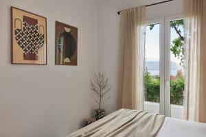 a bedroom with a bed and a window at Iliana Olive Branch in Adamantas