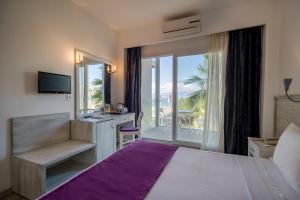 a hotel room with a bed and a balcony at CHARM BEACH HOTEL in Akyarlar +37 photos