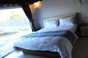 a bedroom with a large bed with a window at Al khitaym guest house in Sa‘ab Banī Khamīs