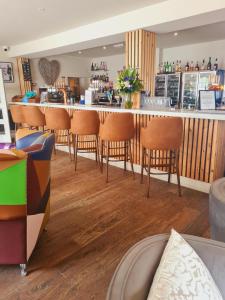 a bar with brown chairs in a restaurant at The Dormy House Hotel in Cromer