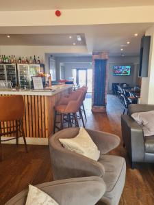 a bar in a restaurant with chairs and a counter at The Dormy House Hotel in Cromer