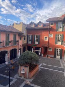 a group of buildings in a courtyard with a bush at La Corte di Vicolo Torre in Uboldo