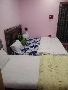 two twin beds in a room with at Chand Tara paying Guest house in Srinagar